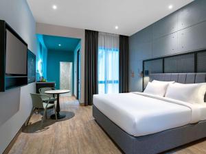 雪邦ibis Styles Sepang KLIA的酒店客房设有一张白色大床和一张书桌