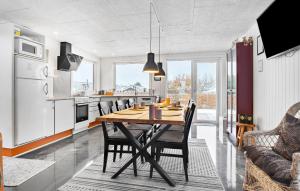 阿森斯Gorgeous Home In Assens With Kitchen的厨房以及带木桌和椅子的用餐室。