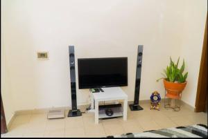 OuétoMaison d'hôte zouma的客厅配有平面电视和桌子。