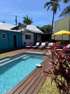 圣若瑟Maison avec piscine chauffée - 8 personnes - Sud Réunion的一座带木甲板的游泳池,位于一座房子旁边