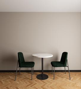 慕尼黑Numa Munich Obersendling的白色墙壁前的两把椅子和一张桌子