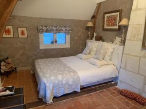 洛什Le Clos Mademoiselle的一间卧室配有一张带白色床单的床和一扇窗户。