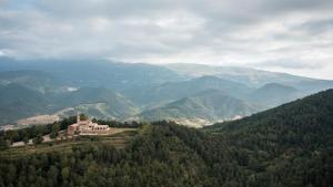 圣胡安-德拉斯阿巴德萨斯Abbatissa Hotel Restaurant的山丘上以山为背景的房子