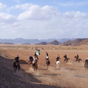 瓦迪拉姆Wadi rum galaxy camp的一群在沙漠里骑马的人