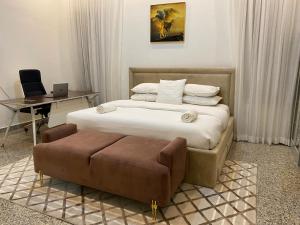 拉各斯Maestro的一间卧室配有一张床、一把椅子和一张书桌