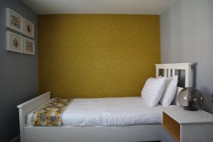塞奇菲尔德Hardwick Arms Hotel的一间卧室配有一张黄色墙壁的床