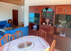 Flámbourasxanthi's sea front villas的一间带桌子和蓝色沙发的用餐室