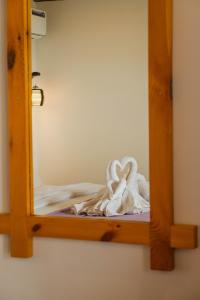 阿贡达Agonda Serenity Resort的一面镜子,上面有两只用毛巾制成的天鹅