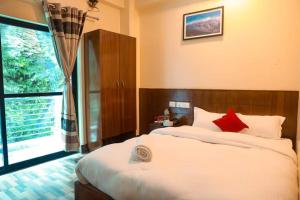 BeniShrestha Hotel Hotspring PVT.LTD的一间卧室设有一张大床和一个大窗户