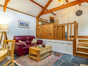 North Huish1 Bed in Bigbury-on-Sea 88096的客厅配有红色的沙发和桌子