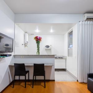 贝洛奥里藏特马科斯萨瓦西服务公寓的白色的厨房配有两把椅子和台面