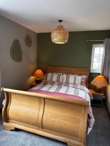 埃文河畔斯特拉特福The Hideaway的一间卧室配有一张带两盏灯的木床。