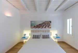 米克诺斯城Fortan 5* villa的一间白色卧室,房间内设有一张大床
