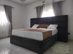 洛美Dapi Home Residence的一间卧室配有一张大床和大床头板
