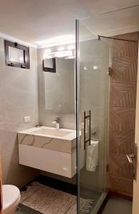 An NakhlahElite Residence - Furnished Apartments的一间带水槽和玻璃淋浴的浴室