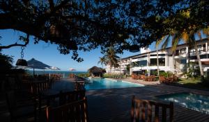 安谢塔Hotel Pontal de Ubu的一个带游泳池和桌椅的度假酒店