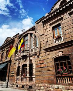 昆卡维多利亚酒店的前面有两面旗帜的建筑