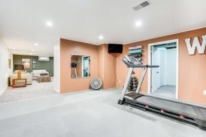 卡拉马祖Wicks Home - Desirable Neighborhood Near Downtown home的一个带跑步机的健身房和一个客厅