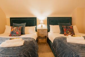 塔文Newly renovated 3 bed Tarvin home -sleeps up to 11的配有两张单人床的房间,配有台灯