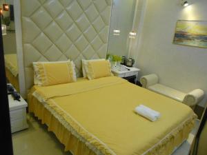 芹苴Thanh Hằng Homestay的一间卧室配有一张大黄床和大床头板