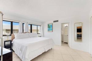基拉戈Overlooking Marina/Ocean view & FREE GOLF CART的白色的卧室设有一张大床和一间浴室。