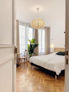 马赛- - Maison ŪMA - Marseille - - Wifi, Mer et Centre的一间卧室配有一张床和一个吊灯
