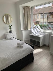 伦敦Gresham House - London Excel的一间卧室设有一张床和一个大窗户