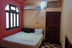 RobertsganjOYO Prabha Guest House的小房间设有床和窗户
