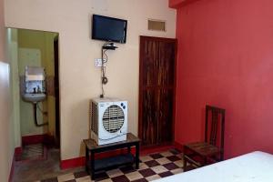 RobertsganjOYO Prabha Guest House的一间设有床铺和墙上电视的房间