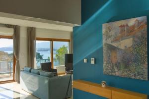 沃洛斯Sunset city apartment的客厅配有沙发和墙上的绘画