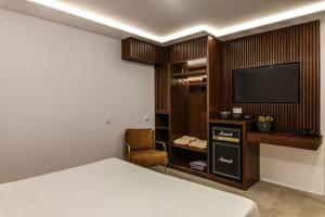 PlintriCharisma Hotel and Wellness Suites的配有一张床和一台平面电视的酒店客房
