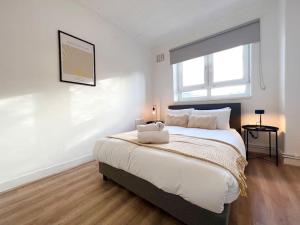 伦敦2 Bed- Belsize Park的一间卧室设有一张大床和大窗户