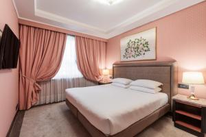 米兰Doria Grand Hotel的一间卧室设有一张大床和一个窗户。