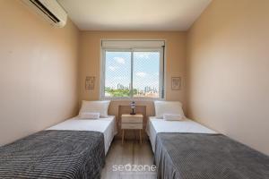 阿雷格里港Confortável apto em Porto Alegre/RS PRL0602的带窗户的客房内的两张床