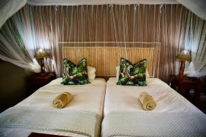 利文斯顿Zambezi Dusk的卧室内的两张床和枕头