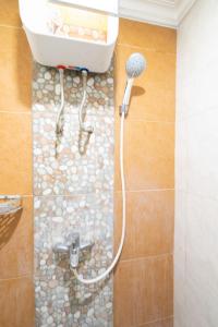 万隆THE SUITES METRO BY GOODVIBES APARTMENT的带淋浴的浴室(铺有石质地板)