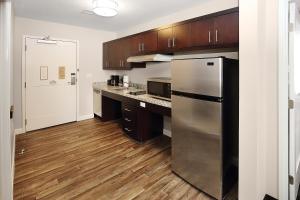 格罗夫城默瑟县格罗夫城/奥特莱斯万豪广场套房酒店的厨房配有不锈钢冰箱和木制橱柜