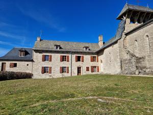 Florentin-la-CapelleAncien Presbytère, gîte familial的一座大型石头建筑,前面有草地