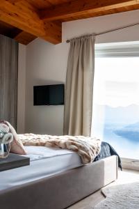 ParzanicaMIA ISOLA with lake view, garden and swimming pool的一间卧室设有一张大床和大窗户