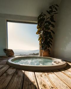 CerquidoCerquido by NHôme的铺有木地板的热水浴池,设有窗户