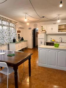 Refúgio dos Mauzinhos的厨房配有白色橱柜和木桌