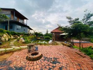 保禄Lam Nguyên Farm Stay的房屋前方设有喷泉的砖砌庭院