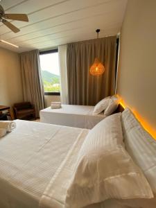 朱奎Pousada Yamandu的配有窗户的酒店客房内的两张床