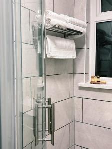 卡马森Penybont Restaurant + Inn的浴室设有玻璃淋浴间和毛巾