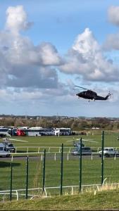 安特里Aintree Grand National Home的直升机用汽车飞越一个田野