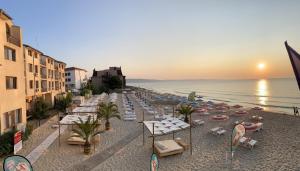 克兰内沃Palma Beach Hotel的海滩上设有椅子和遮阳伞,还有大海