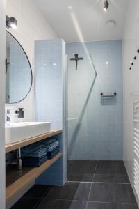 韦默尔丁厄Chezeehoeve - Wemeldinge的浴室设有水槽、镜子和蓝色瓷砖