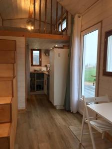 Boissy-sur-DamvilleTiny house à la ferme près Paris et center parcs.的客房设有厨房、桌子和窗户。