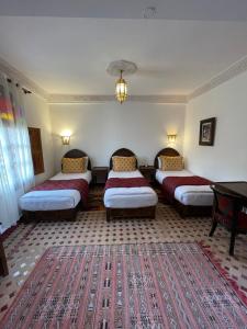 非斯Riad Dar Laura的一间设有四张床和地毯的房间
