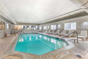 纳科多奇斯Comfort Suites Nacogdoches的游泳池位于酒店带椅子的房间内
